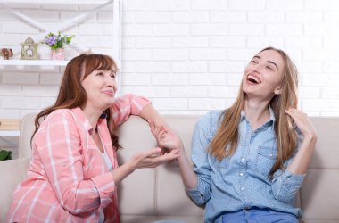 Anne ve kızı evde konuşuyorlar ve eğleniyorlar. İlişkiler ve aile sevgisi. Boşluğu kopyala.