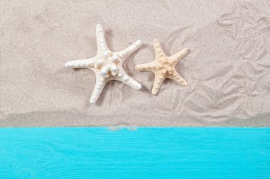 Kum tahtasının üstünde deniz yıldızları.
