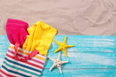 Kum manzaralı tahta üzerinde havlular olan plaj çantası fotokopi alanı