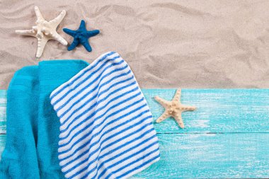 Kum kopyalama alanı. Kum arkaplan üst görünümü. Plaj havluları ve deniz yıldızı.