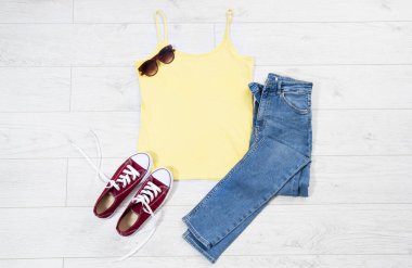 Tişört maket, tişört üstten manzara, sarı yakın plan tişört düz beyaz ahşap arka planda yatıyordu. Üst görünüm ve telif alanı. Model tişört ve yaz tatili. Şablon boş gömlek