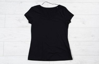 Siyah tişört ahşap zeminin üst görüntüsünü oluşturur.