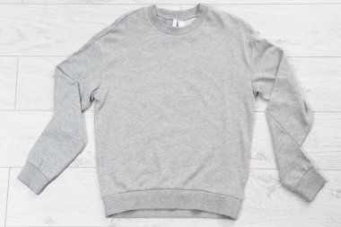 Gri kazak üst görünümü tahta tahta zeminde kopya alanı oluşturur