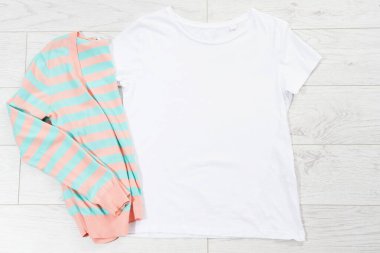 Tişört maketi, tişört üst görünümü, gömleği kapat, maketi düzleştir, tahta arka planda uzan. Üst görünüm ve boşluk kopyala. Model tişört ve yaz tatili. Şablon boş gömlek. Giysi arkaplanı