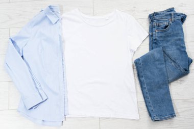 Tişört maketi, tişört üst görünümü, gömleği kapat, maketi düzleştir, tahta arka planda uzan. Üst görünüm ve boşluk kopyala. Model tişört ve yaz tatili. Şablon boş gömlek. Giysi arkaplanı