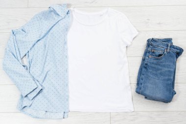 Tişört maketi, tişört üst görünümü, gömleği kapat, maketi düzleştir, tahta arka planda uzan. Üst görünüm ve boşluk kopyala. Model tişört ve yaz tatili. Şablon boş gömlek. Giysi arkaplanı