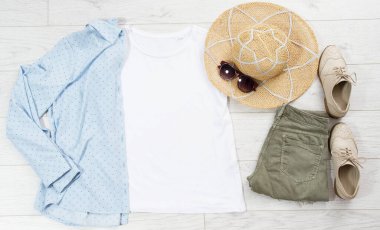 Tişört maketi, tişört üst görünümü, beyaz yakın plan tişört düz beyaz ahşap arka planda yatıyordu. Üst görünüm ve telif alanı. Model tişört ve yaz tatili. Şablon boş gömlek.