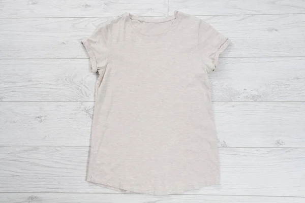 T-shirt top view, t shirt mock up, empty tshirt. Summer concept casual clothes background copy space. Blank shirt on wooden background