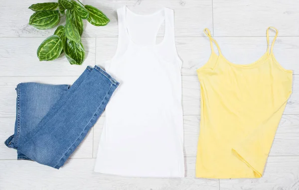 White and yellow T-shirt and jeans denim top view - casual clothes background