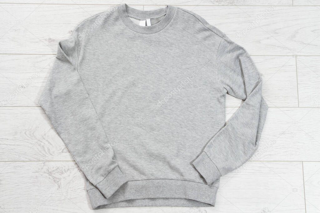 Gray pullover close up top view mock up on wooden floor