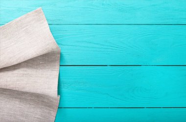 Mavi ahşap arka planda gri keten kumaş. Üst görünüm ve kopyalama alanı.
