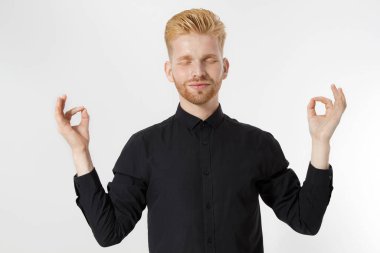 İş başarısı konsepti için meditasyon yap. Genç adam stres ve başarı için asal önem, endişenin üstesinden gel. Meditasyon pozisyonundaki kızıl saçlı adamı yakından çek. Beyazda izole edilmiş. Sakin, berrak zihin