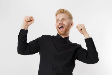 Hayat kazananı ve başarılı genç girişimci. Kızıl sakallı kızıl saçlı adam izole edilmiş. Siyah gömlek tarzı erkek. İskandinav Avrupalı yakışıklı erkek. Başarı başlasın. Mutlu, heyecanlı, şaşkın adam yüzü.