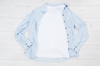 Beyaz yakın plan t-shirt 'ü tahta arka planda düz bir şekilde duruyor. Üst görünüm ve boşluk kopyala. Model tişört ve yaz tatili. Şablon boş gömlek.
