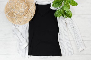 Siyah yakın plan tişört beyaz ahşap arka planda düz duruyor. Üst görünüm ve boşluk kopyala. Model tişört ve yaz tatili. Şablon boş gömlek.