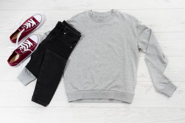 Gri boş şablon kapüşonlu kapüşonlu kapüşonluyu fotokopi alanı ile kapat. Beyaz ahşap arka planda üst görünüm model kazak. Sıradan kıyafet. Düz şablon giysiler serildi.