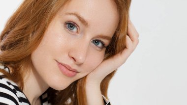 Makro suratlı kızıl saçlı kız beyaz arka planda izole edilmiş. Kadın güzelliği ve cilt bakımı. Makyaj yok. Kızıl saçlı güzel kadın. Seçici odaklanma. Pankart