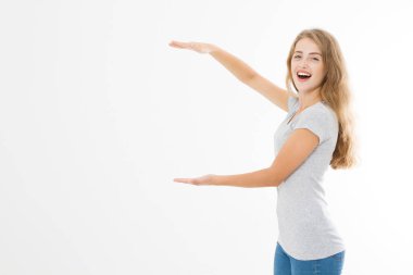 Reklam panosu. Yazlık tişört giyen gülümseyen sarışın beyaz kadının portresi beyaz şablon ve boş arkaplanda parmak izolasyonu ile fotokopi alanını işaret ediyor. Şok olmuş ve heyecanlı yüz..