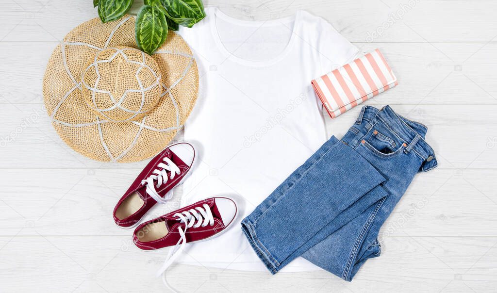 T shirt white and sneakers. T-shirt Mockup flat lay with summer accessories. Hat, jeans and sneakers on wooden floor background. Copy space. Template blank canvas. Front top view.