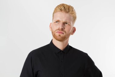 Adam düşünür, kızıl saçlı ciddi düşünür stüdyoda düşünceli bir portre beyaz arka planda izole edilmiş, siyah gömlekli genç çekici bir adam.