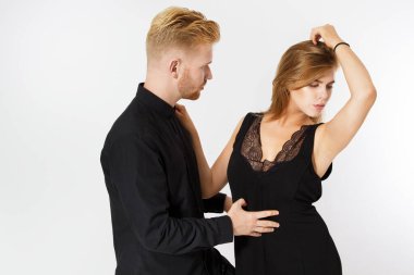 Siyah elbiseli şık genç bir çift beyazın üzerinde izole edilmiş. Birbirine bakan bir çift.