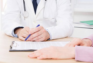 Doktor ve hasta bir şey tartışıyorlar, sadece ellerini masaya koy, sağlık sigortası..