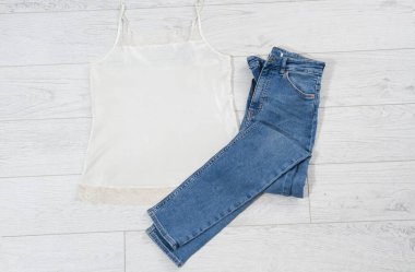 Beyaz ahşap arka planda katlanmış mavi kot, açık ahşap arka planda katlanmış kot - üst görünüm