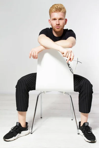 Sandalyede Oturan Genç Adam Sandalyede Oturan Yakışıklı Genç Adam Portresi — Stok fotoğraf