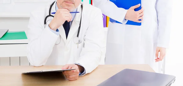 Doctor Posando Consultorio Con Personal Médico Que Está Usando Estetoscopio —  Fotos de Stock