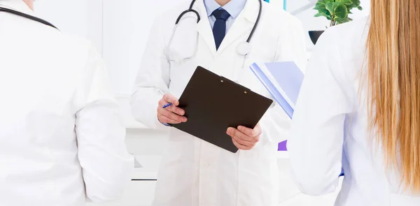 Doctor Posando Consultorio Con Personal Médico Que Está Usando Estetoscopio — Foto de Stock