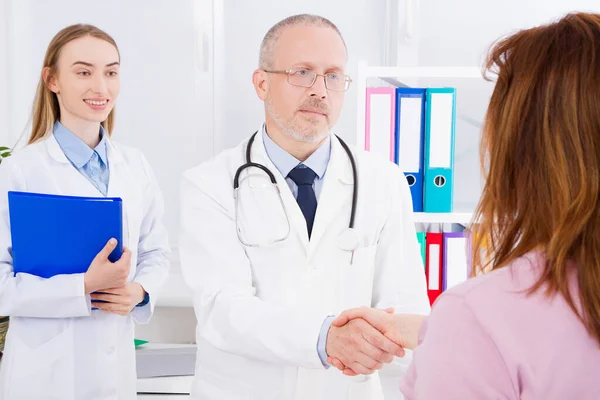 Doctor Posando Consultorio Con Personal Médico Que Está Usando Estetoscopio —  Fotos de Stock