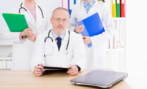 Médico Posando Escritório Com Equipe Médica Ele Está Usando Estetoscópio — Fotografia de Stock