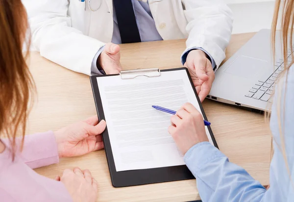 doctor discusses with patients medical contract at the clinic, medical insurance