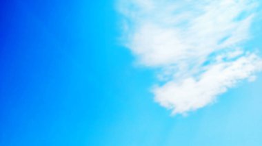 Bulanık arkaplan gökyüzü bulutları: Sabah arkaplanı boyunca güneş ışığı bulutları gökyüzü. Mavi, beyaz pastel cennet, yumuşak odaklı lens güneş ışığı. Barışçıl doğanın soyut buğulanmış Cyan gradyanı. Mavi gökyüzü arkaplan kopyalama alanı.