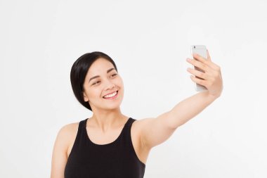 Genç Asyalı Japon kız beyaz arka planda izole edilmiş cep telefonuyla selfie çekiyor. çalışma ya da