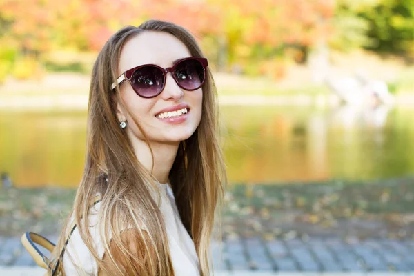 Beautiful happy girl in sunglasses smiling on a park background Close Up, portrait of beautiful stylish smile woman closeup