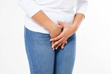 Elleri kasıklarına bastıran genç, hasta, zenci bir kadın. Tıbbi ya da jinekolojik sorunlar kavramı