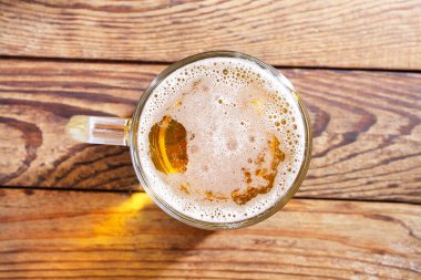 Ahşap arka planda bir bardak bira, üst manzara. Model yap. Uzayı kopyala. Şablon. Boşluk.