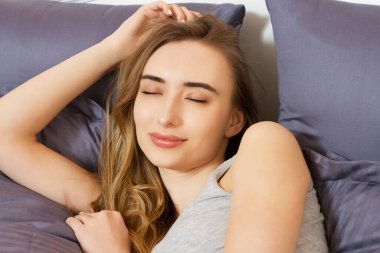 Güzel kız yatak odasında uyuyor. Yatakta uyuyan kadın, yakından çek. Genç ve güzel bir kadın uyuyor. Karanlık yatakta uyuyan güzel genç kadının portresi..