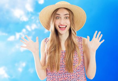 Mavi gökyüzünün arka planında gülümseyen şapkalı güzel duygusal kadın.