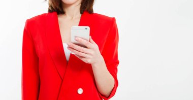 Modern kırmızı elbiseli güzel esmer kadın telefonu beyaz arka planda izole etmiş.
