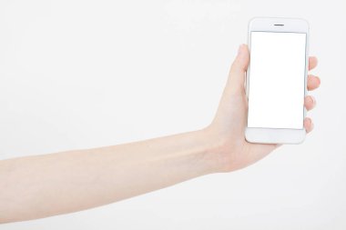 El ele tutuşan beyaz cep telefonu içerideki beyaz kırpma yolunda izole edilmiş. İnternetten alışveriş. Üst Manzara. Model yap. Uzayı kopyala Şablon. Boşluk..