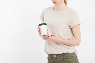 Beyaz telefon tutan bir kız. Plastik bardak kahve. İçerideki beyaz kırpma yolunda hücresel izole. Üst görünüm. Model. Boşluğu kopyala. Boşluk..