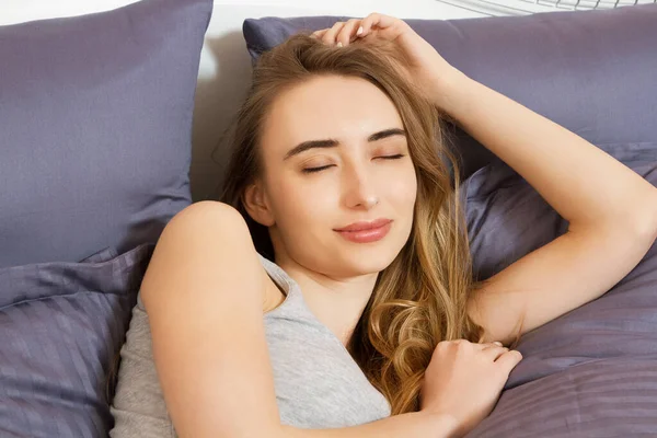 Kapat. Mutlu kız sabah yatakta uyanıyor. Uyuyan kadın yüzü.