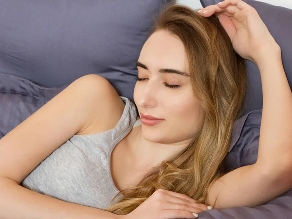 Güzel kız yatak odasında uyuyor. Yatakta uyuyan kadın, yakından çek. Genç ve güzel bir kadın uyuyor. Karanlık yatakta uyuyan güzel genç kadının portresi..