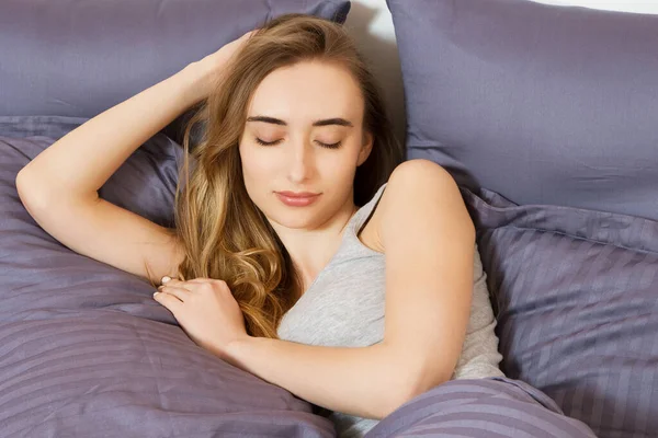 Güzel kız yatak odasında uyuyor. Yatakta uyuyan kadın, yakından çek. Genç ve güzel bir kadın uyuyor. Karanlık yatakta uyuyan güzel genç kadının portresi..