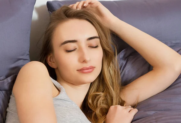 Yatakta uyuduktan sonra gözleri kapalı güzel bir kızın portresi.