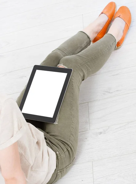 tablet with a blank display on the girl\'s lap at home