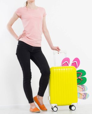 Bavullu kız beyaz arka planda izole edilmiş. Yaz terlikleri ya da terlikler. Seyahat valizi ya da çanta. Model yap. Uzayı kopyala Şablon. Boşluk.