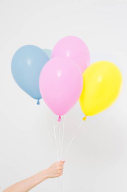 El ele tutuşan balonlar. Tatil konsepti. Renkli parti balonları arka planı. Beyazda izole edilmiş. Boşluğu kopyala